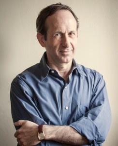 A man in a blue shirt with his arms crossed.