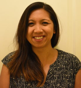 A smiling woman in a black and white shirt.