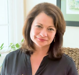 A woman in a black shirt sitting in a chair.