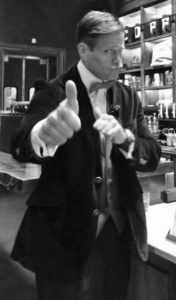 A man in a suit giving a thumbs up.
