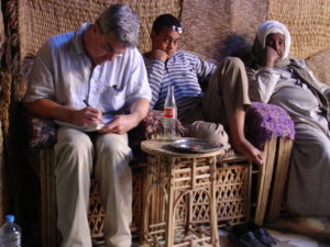 A man sitting on a wicker chair.