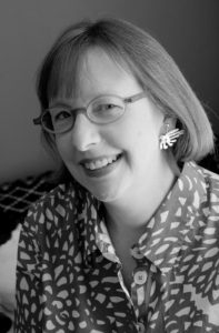 A black and white photo of a woman smiling.