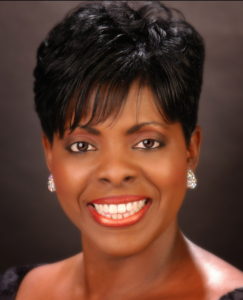 A woman with short black hair smiling for the camera.