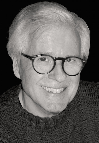 A black and white photo of an older man wearing glasses.