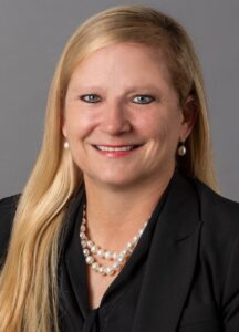 Headshot of blonde woman in black blazer.